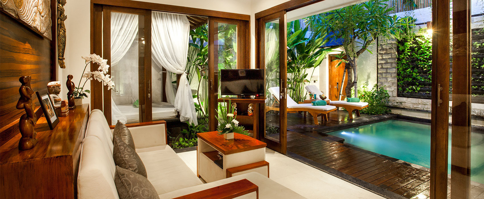 Interior living room of a 1-bedroom pool villa at Astagina Resort with a view of the private pool.