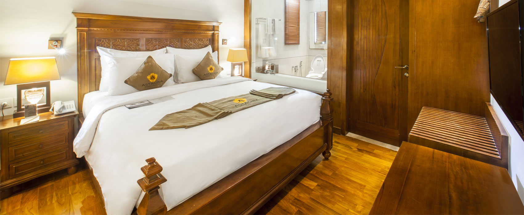 Master bedroom of Arana Two Bedroom Garden Villa at Astagina Resort with traditional wood decor.