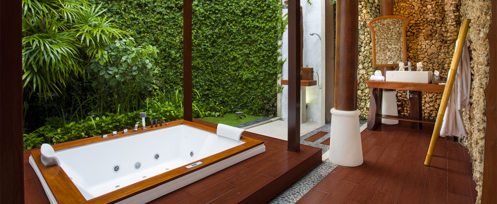 Tropical villa bathroom featuring a large whirlpool tub and outdoor shower at Astagina Resort
