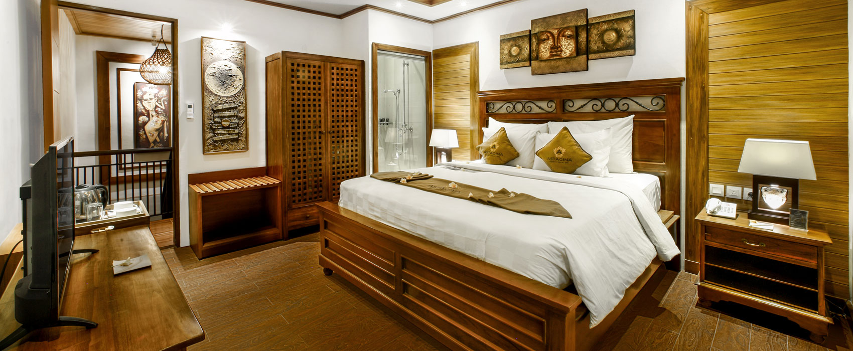 Elegant master bedroom of Purana Temple Villa at Astagina Resort with traditional wood decor.