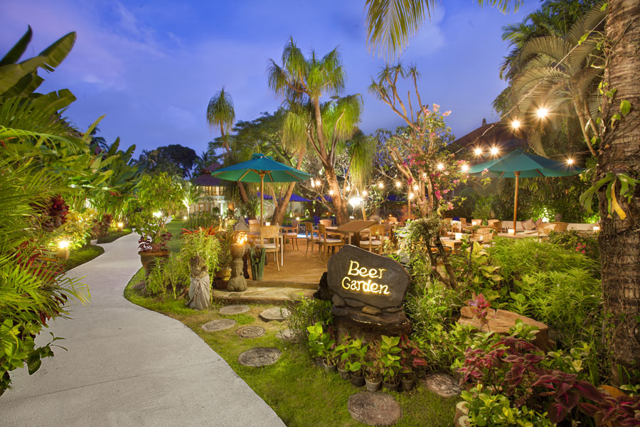 A welcoming entrance to the Beer Garden at Astagina Resort & Spa, featuring an illuminated stone sign.