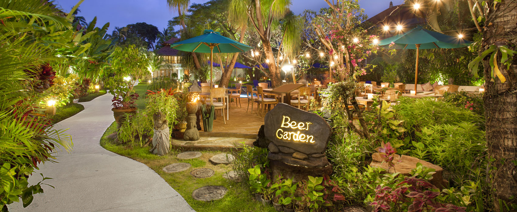 Outdoor beer garden sitting area at Astagina Resort Bali with a warm and inviting ambiance.