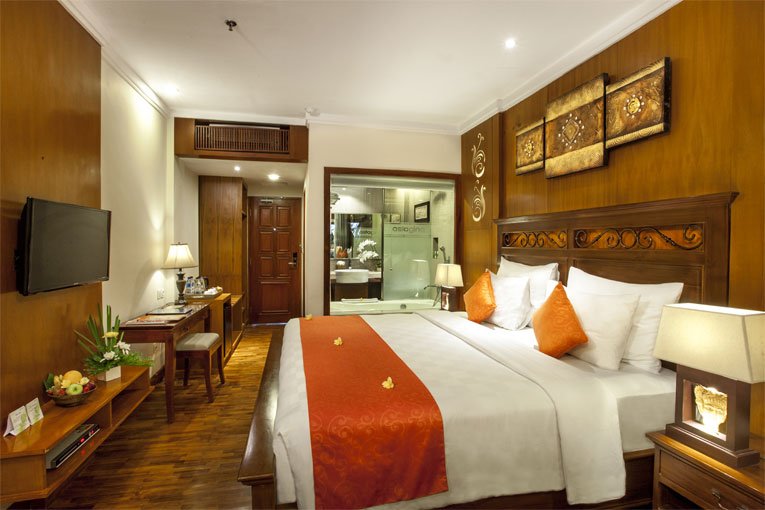 Elegant Deluxe Room at Astagina Resort with Balinese wooden accents.