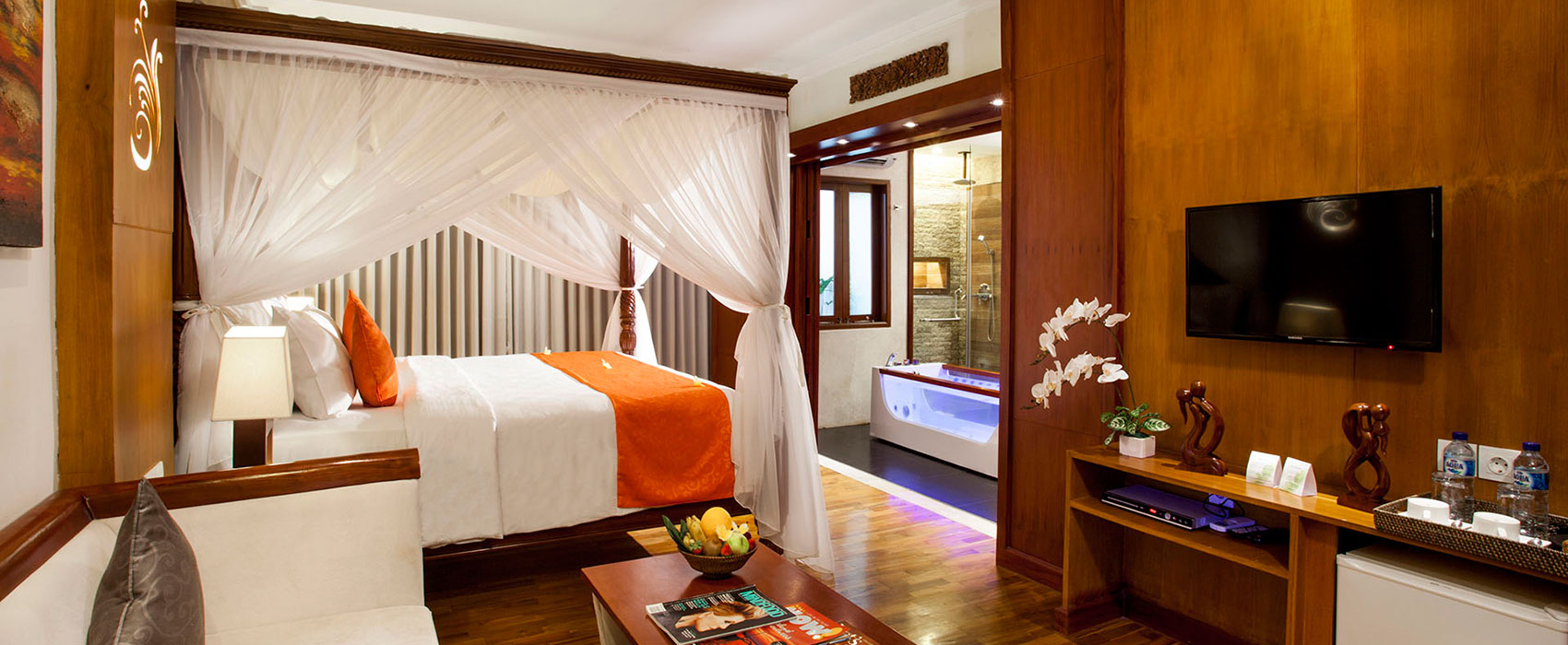 Luxury suite at Astagina Resort featuring a canopy bed and an indoor jacuzzi with ambient lighting.