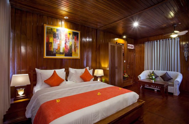 Cozy one-bedroom interior featuring warm wooden design and Balinese decor at Astagina Resort.
