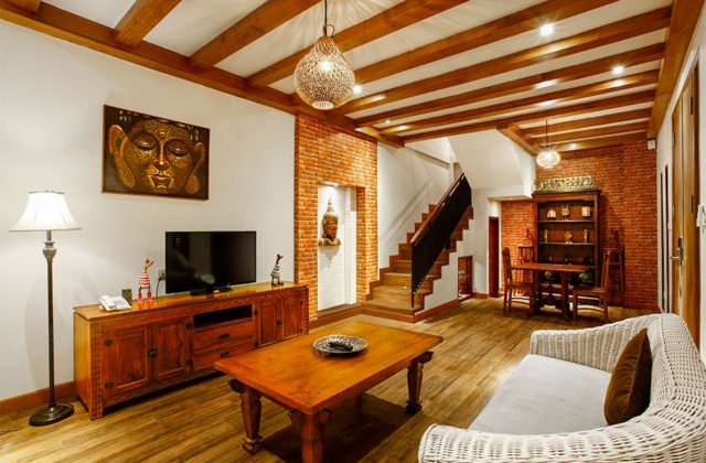 Cozy living room area equipped with a comfortable sofa and TV entertainment system in the private villa.
