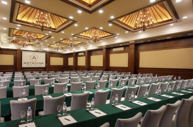Full view of the conference hall layout facing the main stage presentation area at Astagina Resort.