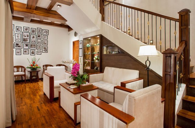 Spacious two-story villa living room area with a staircase leading to the upper level at Astagina Resort.
