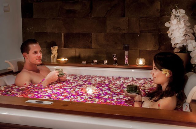 Honeymoon couple enjoying a romantic flower bath moment together at Astagina Resort Bali.
