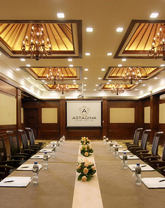 Elegant boardroom at Astagina Resort with high-back chairs and chandeliers.