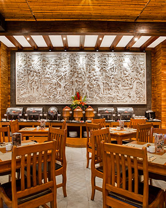 Elegant restaurant dining area at Astagina Resort with traditional wooden furniture.
