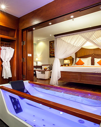 Luxury suite at Astagina Resort featuring an indoor jacuzzi and canopy bed.