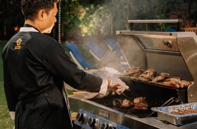 Professional chef grilling fresh BBQ dinner for guests at Astagina Resort Bali during the evening.