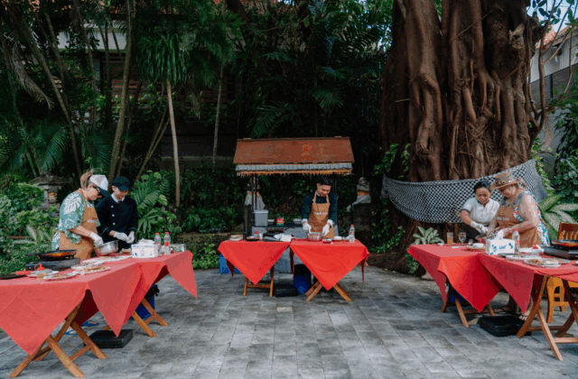 Outdoor traditional Balinese cooking class experience in the tropical garden of Astagina Resort Bali.