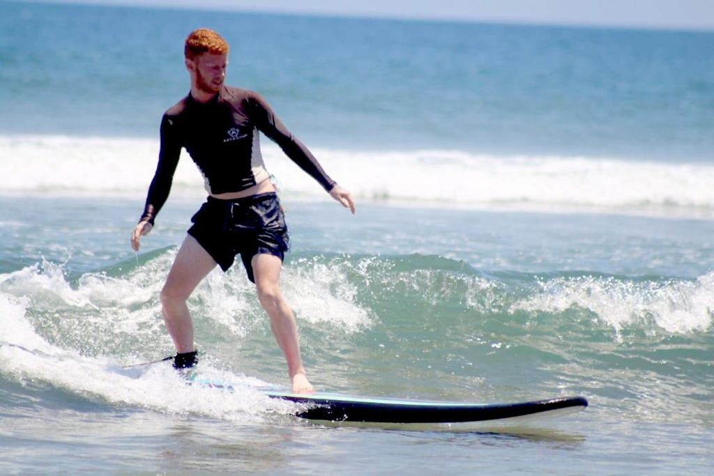 Guest surfing small waves near Astagina Resort, Bali.