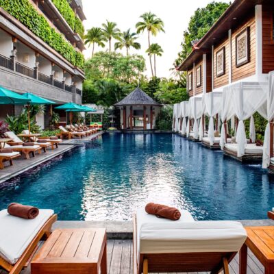 Main swimming pool at Astagina Resort with cabanas and tropical courtyard setting.