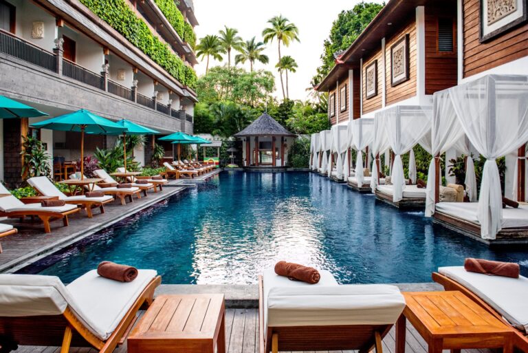 Main swimming pool at Astagina Resort with cabanas and tropical courtyard setting.