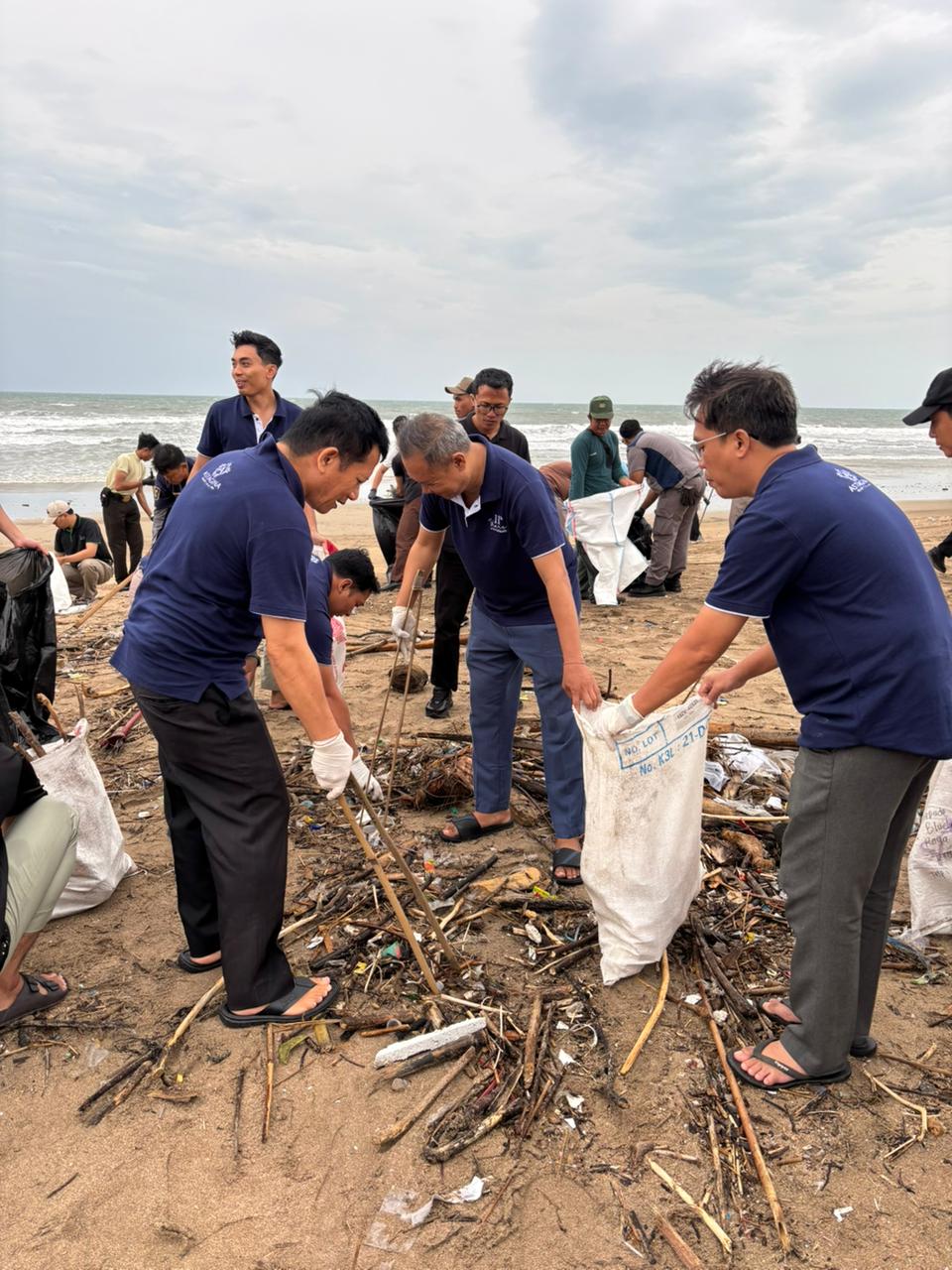 Astagina Resort team members filling waste sacks during a beach clean-up programme on Legian Beach Bali — part of the resort's ongoing environmental commitment