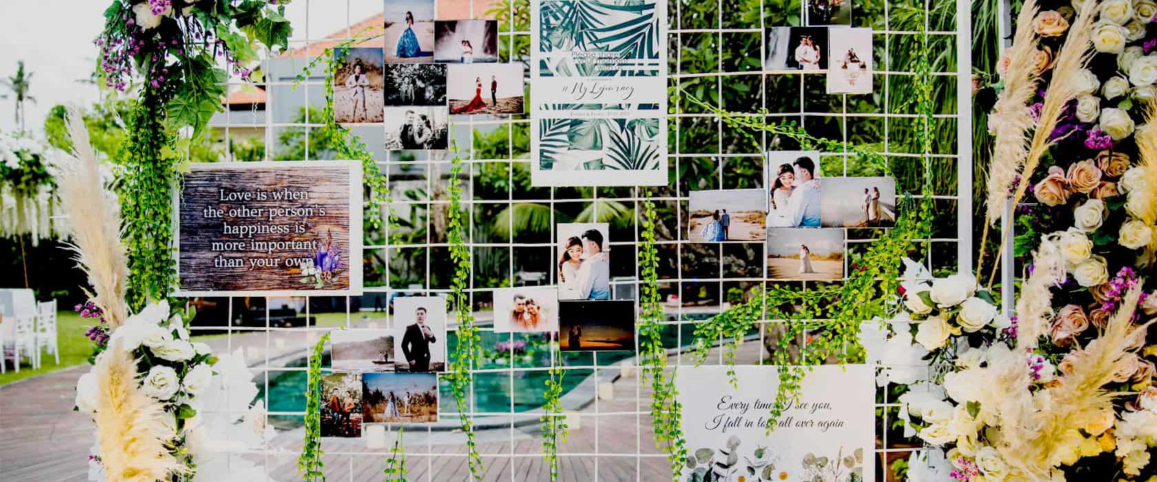 Personalized wedding photo wall display at an outdoor reception in Astagina Resort.