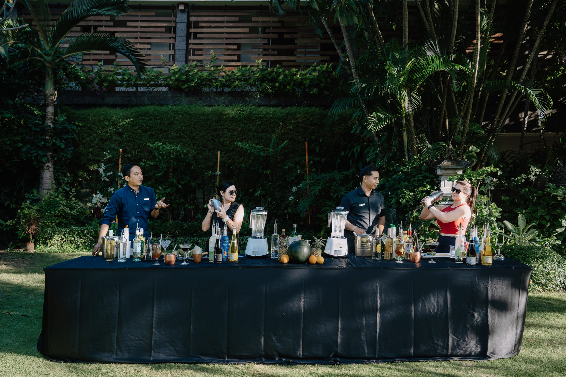 Astagina Resort staff and guests participating in an outdoor cocktail making activity in the tropical garden Legian Bali