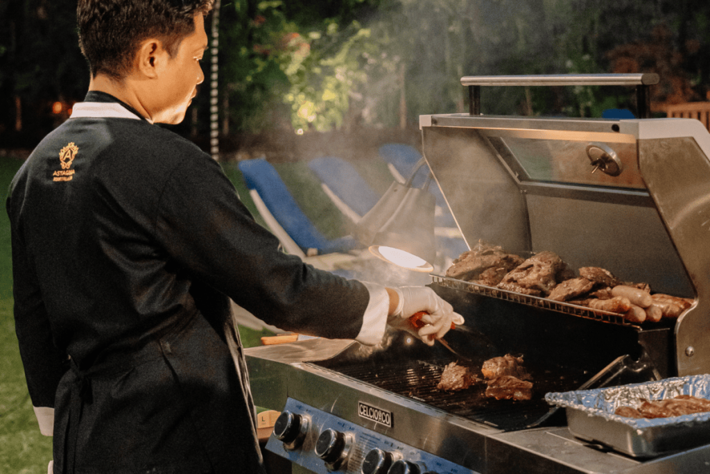 Professional chef grilling fresh BBQ dinner for guests at Astagina Resort Lagian during the evening