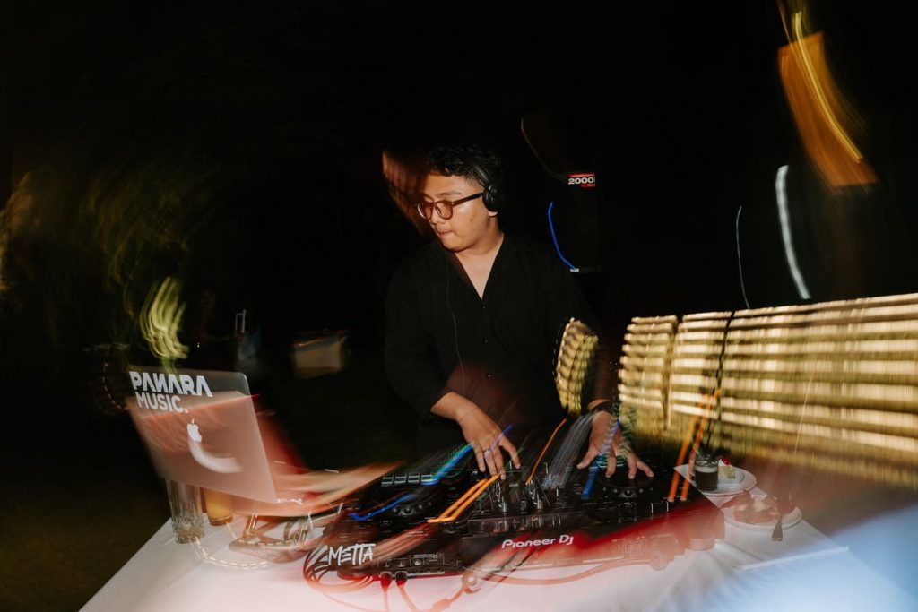 DJ performing at an outdoor Bali wedding party reception at Astagina Resort garden venue in Legian