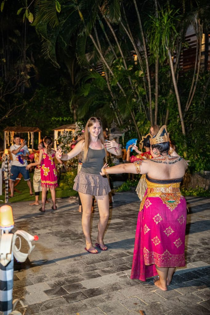 A tourist joins traditional dancers during the Balinese Night Buffet at Pangi Bistro Astagina Resort Legian