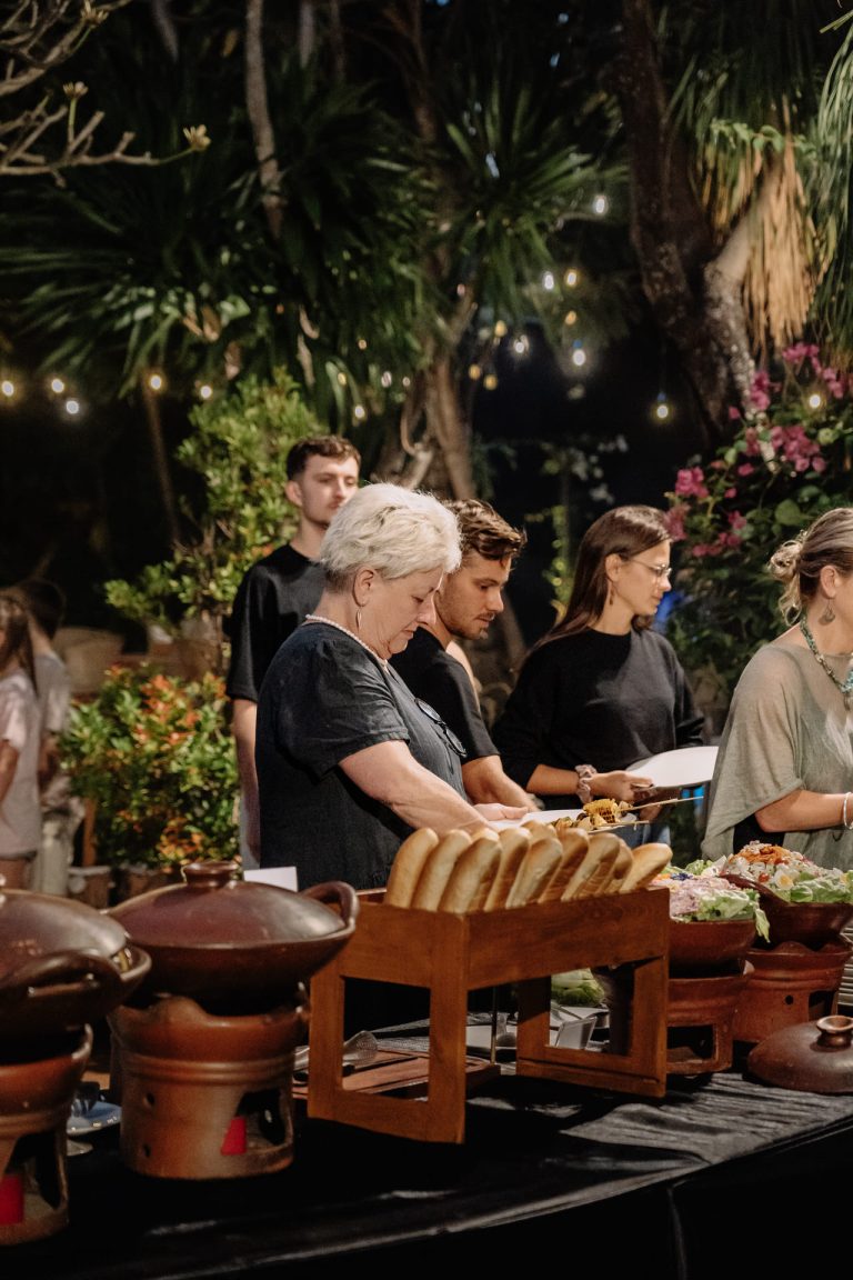 Guests lining up at the Balinese Night Buffet spread with bread and traditional dishes in the Banyan Garden, Astagina Resort