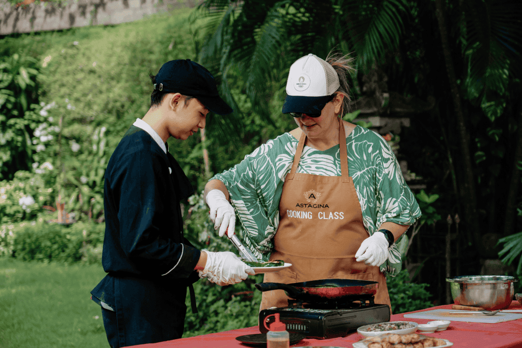 Guests learning to prepare authentic traditional Balinese dishes during the cooking class at Astagina Resort.