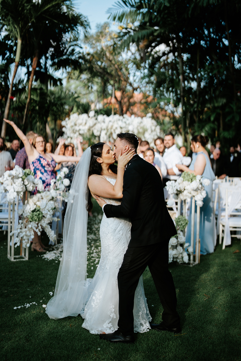 Bride and groom share a kiss at the end of the aisle, Astagina garden wedding ceremony Legian
